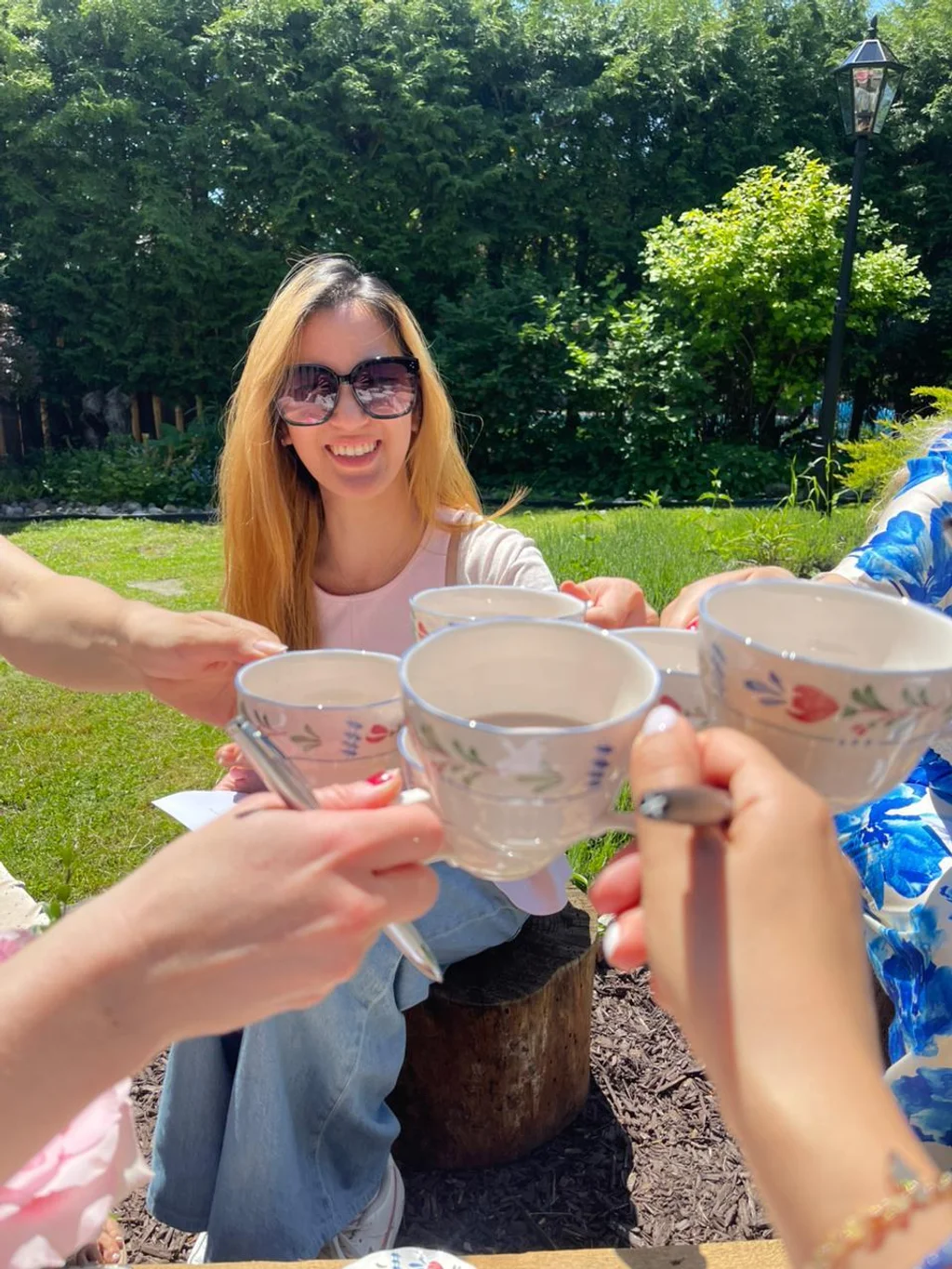 Guests raising cacao cups in a toast in the garden