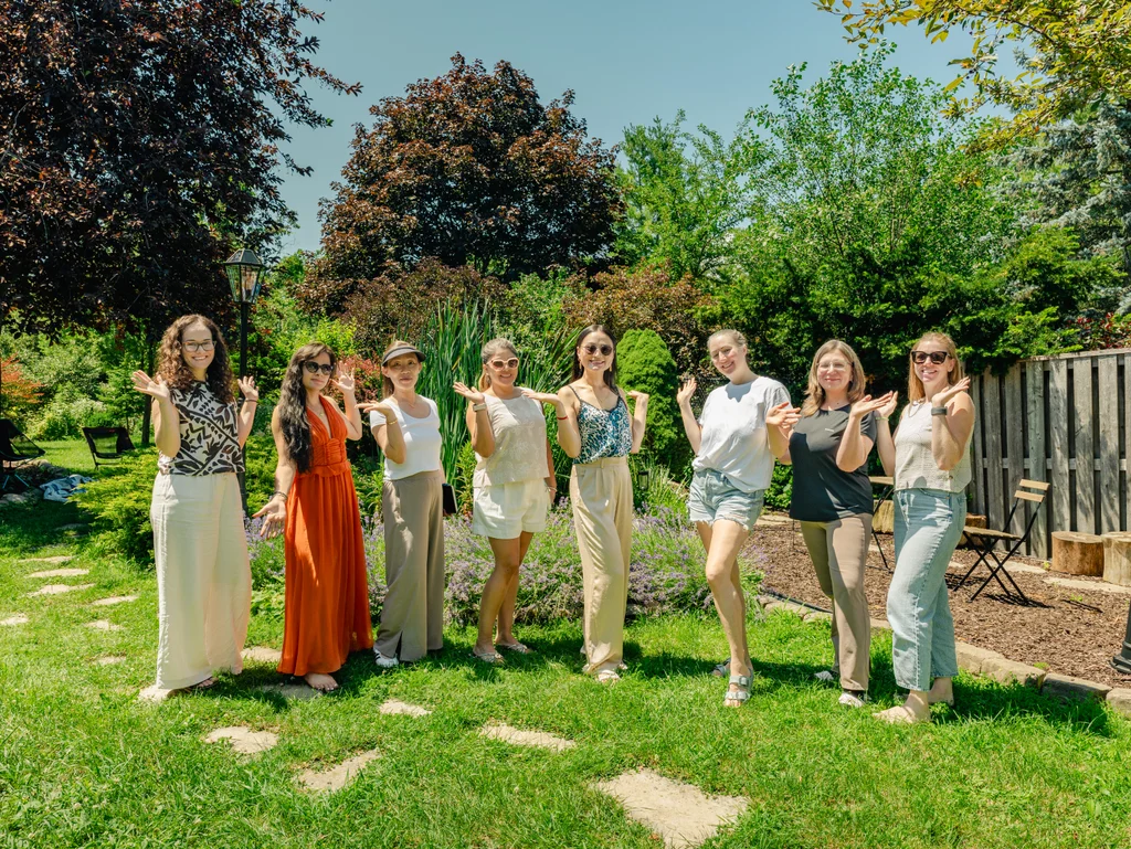The full group standing together in the garden