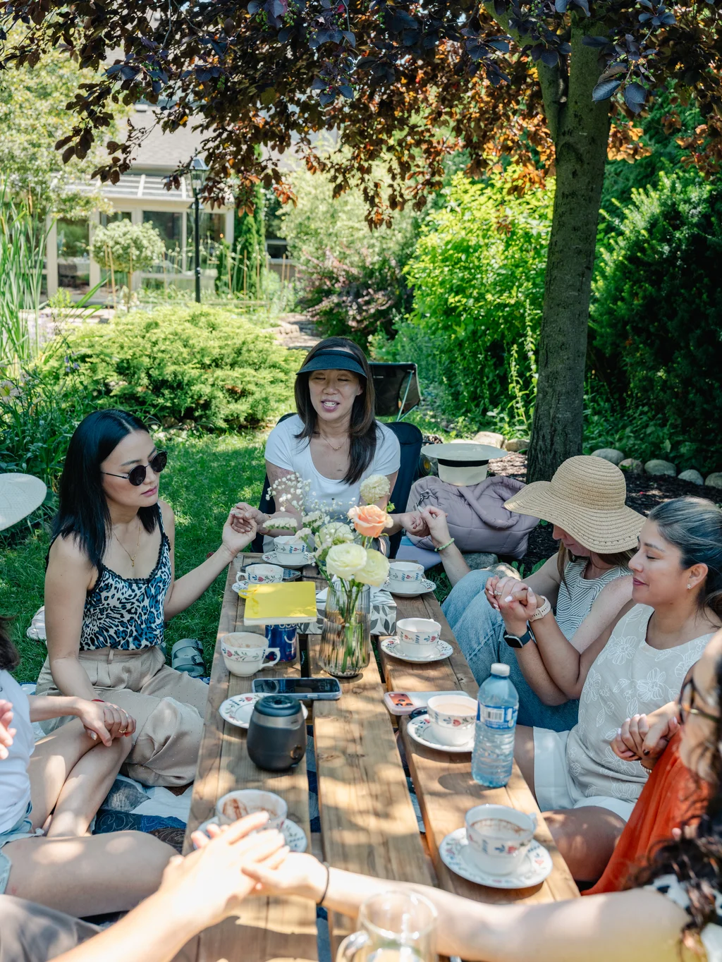 Guests holding hands around the garden table