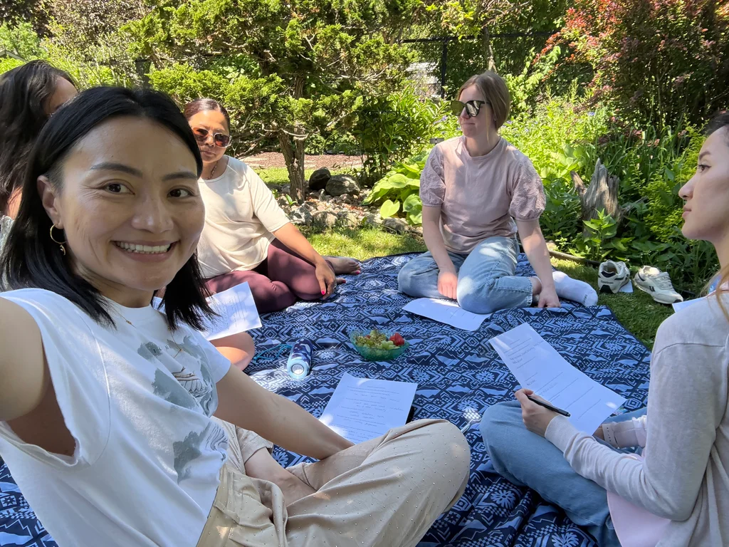 Group reflection and journaling on a blanket outdoors