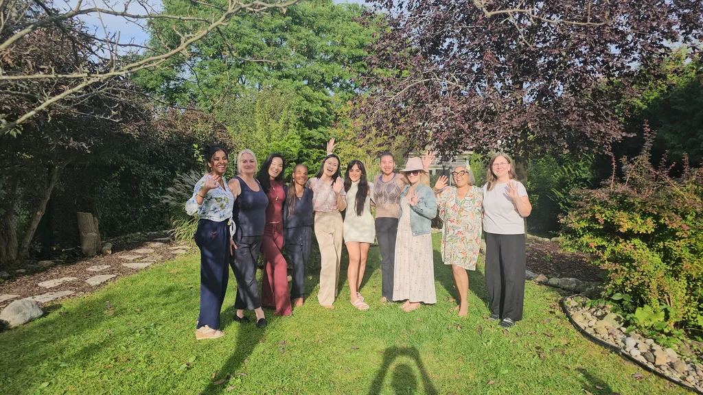 Retreat guests smiling and waving together in the garden